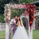 Wedding archway on the backyard and happy wedding couple outdoors before wedding ceremony